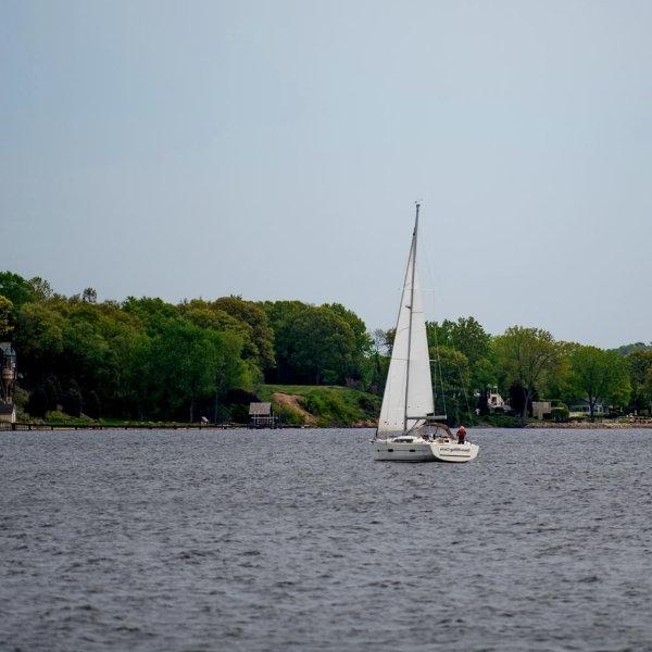 A sailboat drifts across Muskegon Lake